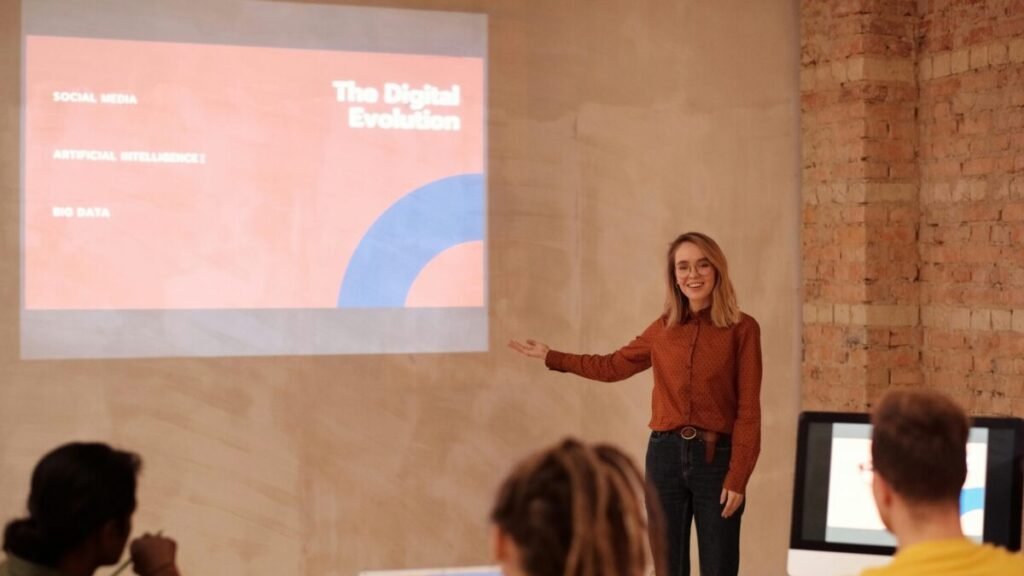 Young woman presenting digital evolution concepts to a classroom audience.