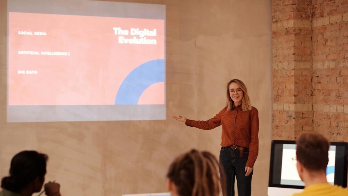 Young woman presenting digital evolution concepts to a classroom audience.