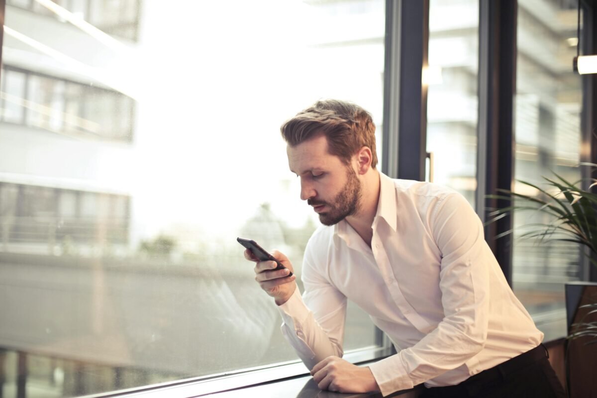 Businessman checking mobile apps on phone.