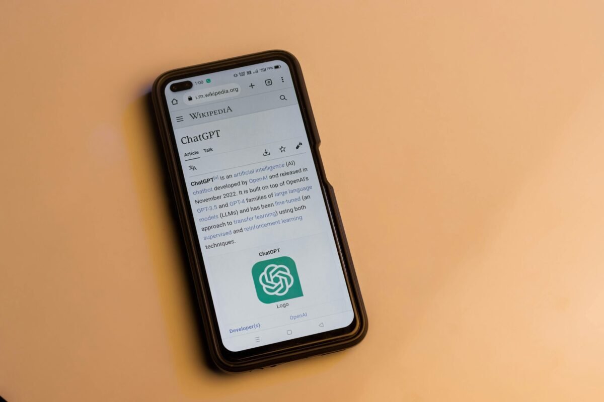 Smartphone displaying the ChatGPT Wikipedia page on a yellow background.