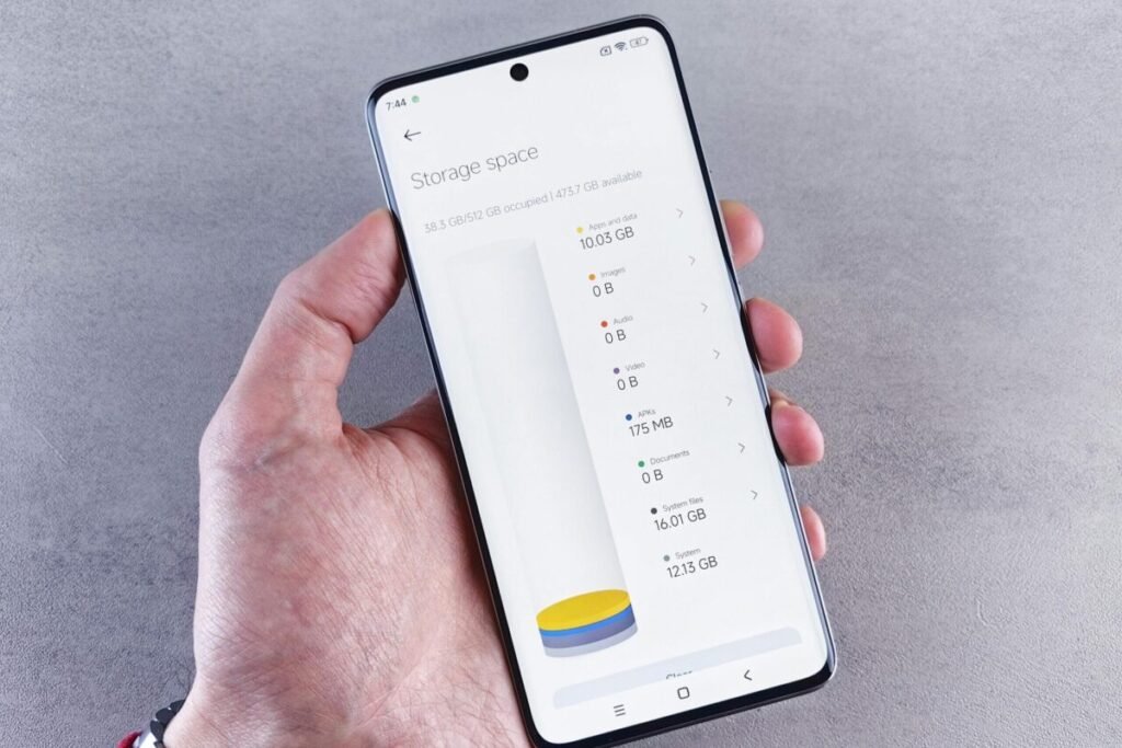 Hand holding a smartphone showing storage space usage on the screen