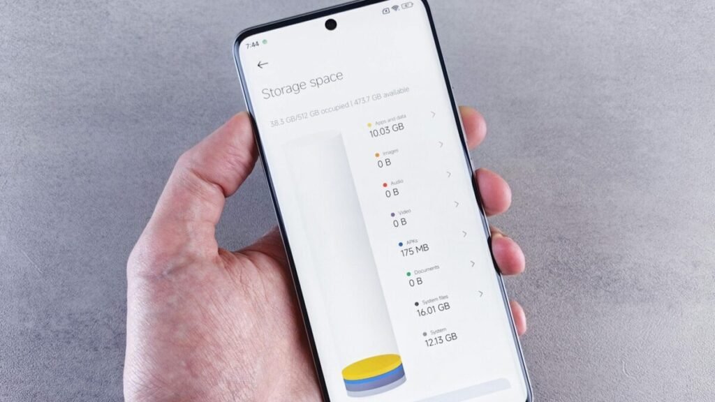 Hand holding a smartphone showing storage space usage on the screen
