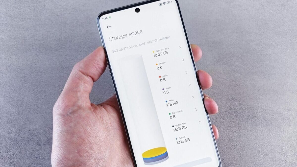 Hand holding a smartphone showing storage space usage on the screen