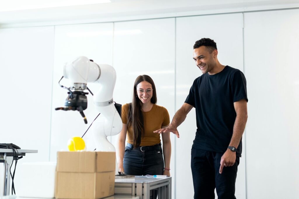 Two people interacting with an AI-powered robotic arm in a tech lab environment
