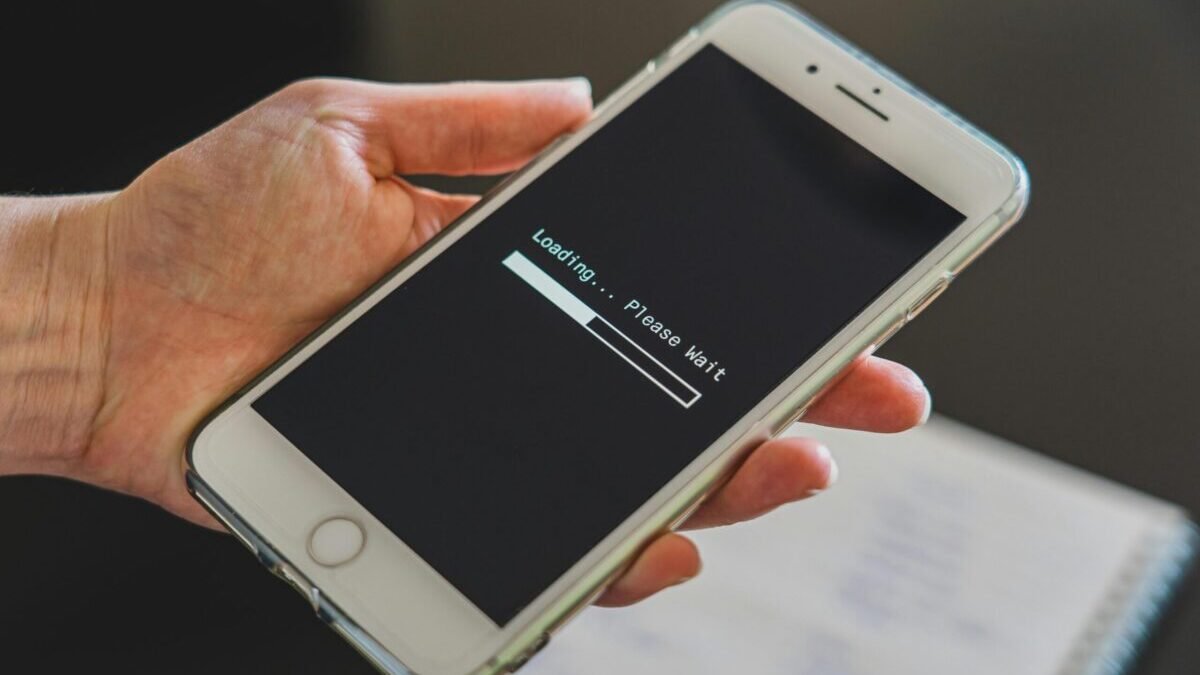Person holding a smartphone with a loading screen displayed, representing hidden or lesser-known phone features.