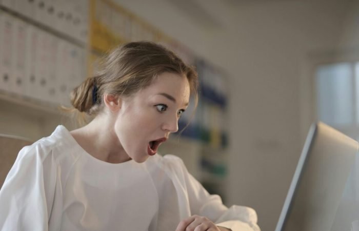 Woman shocked while using laptop.