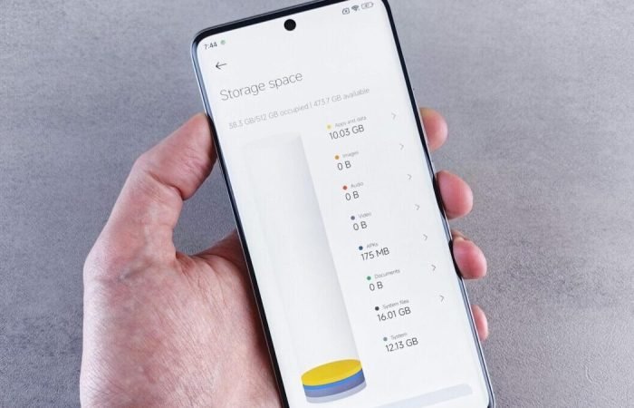 Hand holding a smartphone showing storage space usage on the screen